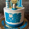 Boss Baby Theme Birthday Cake by Sweet Cakery Bangalore featuring cream finish, baby figurine topper, milk bottle, pacifier, and number 1 design.