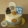 Basketball theme birthday cake from Sweet Cakery with fondant hoop, jersey, ball and star decorations in a sports theme design.