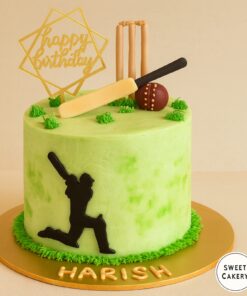 Cricket lover birthday cake from Sweet Cakery in Bangalore featuring green cream base, edible bat, ball, stumps, and black player silhouette.