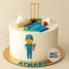 Cricket theme birthday cake from Sweet Cakery with cream finish, decorated with fondant bat, ball, stumps, gloves, jersey and player design.