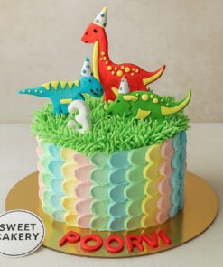 One-tier dinosaur theme birthday cake with colourful dinos, grassy green top, and pastel side design. Sweet Cakery branding on sticker in front.