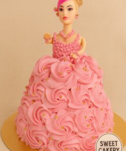 Doll theme cake from Sweet Cakery with pink cream rosette gown, golden pearls, realistic doll topper