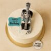 Round cream cake with black and white fondant electric guitar topper for music-themed birthday