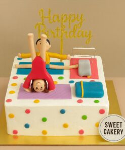 Square gymnastics theme birthday cake with fondant figures doing stretches and headstands on colourful mats, cream finish