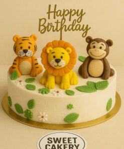 Jungle theme birthday cake with fondant lion, tiger and monkey toppers, decorated with green leaves and white flowers from Sweet Cakery Bangalore