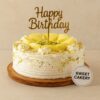 Rasmalai flavour birthday cake by Sweet Cakery, topped with rasmalai pieces, pistachios, white cream frosting, and gold Happy Birthday topper.