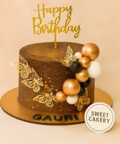 Golden butterfly and balloon cake by Sweet Cakery, featuring metallic balloons, delicate butterflies, and chocolate finish
