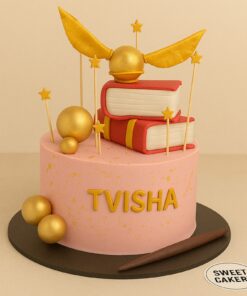 A custom Harry Potter theme cake by Sweet Cakery featuring pink buttercream, golden Snitch, stacked spell books and fondant wand