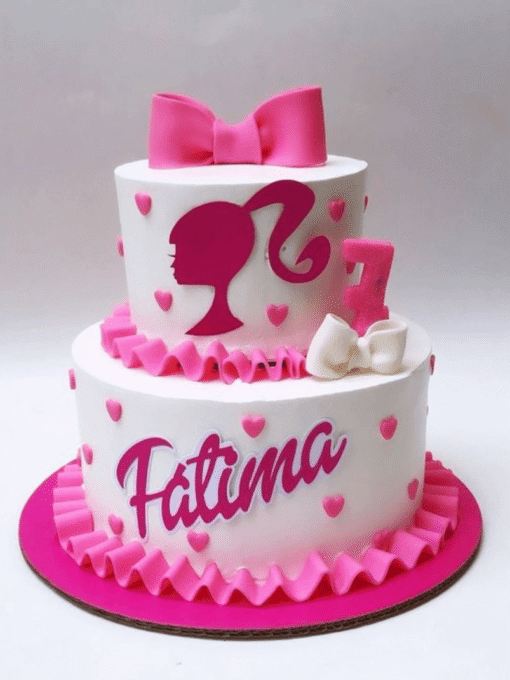 Two-tier Barbie birthday cake with pink silhouette, bows, hearts, and custom name