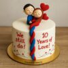 A round 10th anniversary cake with fondant couple hugging on top