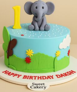 Elephant theme jungle birthday cake with fondant elephant topper, green grass design, colourful flowers, and Sweet Cakery sticker in Bangalore.