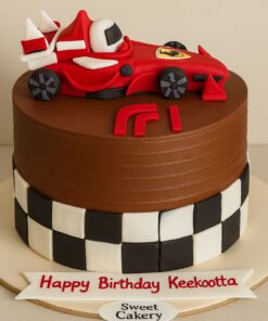 Formula 1 racing theme birthday cake with red race car topper, checkerboard fondant design, and Sweet Cakery sticker in Bangalore.