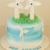 Windmill theme birthday cake with edible fondant turbines, blue gradient buttercream, hand-piped grass, and Sweet Cakery sticker in Bangalore.