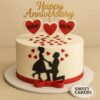 A romantic anniversary cake with black couple silhouette, red heart toppers with names, golden “Happy Anniversary” topper