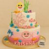 Two-tier Baby Shark theme cake with cream finish, pink-blue ombre base, fondant sharks, sea creatures, seaweed