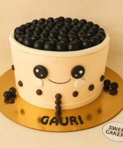Cute boba tea theme birthday cake by Sweet Cakery with black boba pearls, smiling fondant face. 100% eggless, Bangalore.
