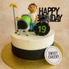 A professional photo of a Drum Theme Birthday Cake by Sweet Cakery in Bangalore, featuring a fondant drummer figurine with a green drum set and band-style decorations.