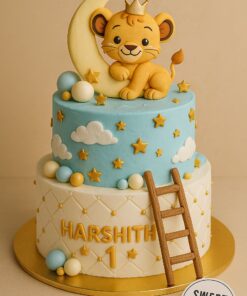 Lion Theme First Birthday Cake by Sweet Cakery in Bangalore. Two-tier cake with a cartoon cub on a crescent moon, quilted base, stars, clouds, and decorative spheres. Perfect for first birthdays, six month birthdays, and young kids’ birthday parties.