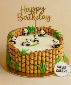Panda theme birthday cake by Sweet Cakery in Bangalore featuring cute panda toppers, wafer stick bamboo border, green leaves, golden topper, 100% eggless custom cake