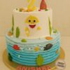 Underwater Baby Shark birthday cake with cream finish, fondant sharks, ocean waves, colourful fish, shells