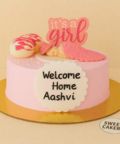 Pastel pink welcome baby cake by Sweet Cakery with fondant sleeping baby, “It’s a girl” topper