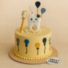 A yellow cream cake with a smiling tooth topper, toothbrush, balloons, and fondant details, from Sweet Cakery Bangalore, designed for a baby’s first tooth celebration.