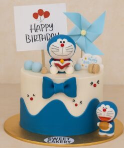 Doraemon theme birthday cake from Sweet Cakery with blue and white icing, cartoon figures, bow, and topper, ideal for kids’ celebrations